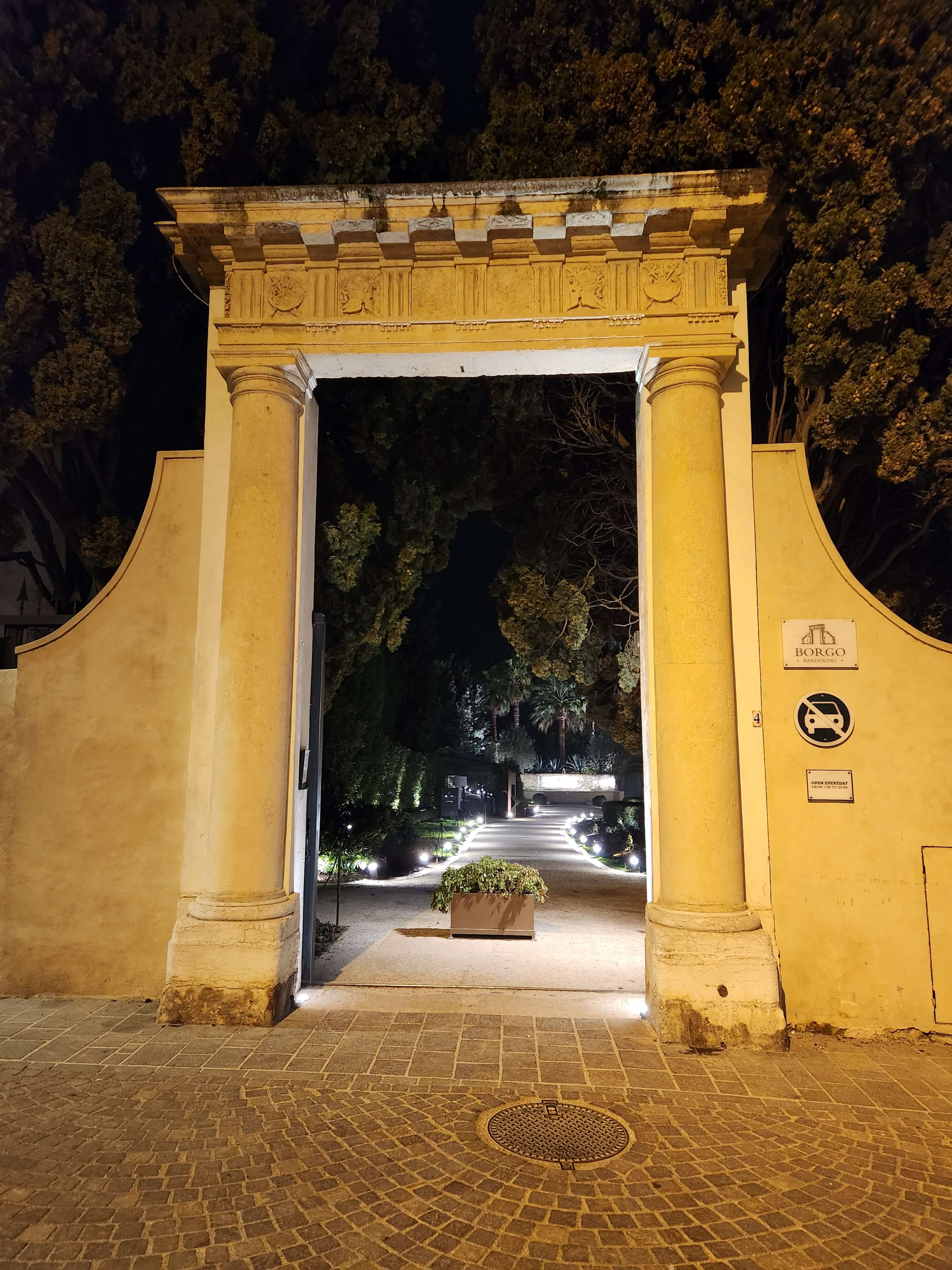 Portail baroque illuminé la nuit à Bardolino, entrée du Borgo, lac de Garde