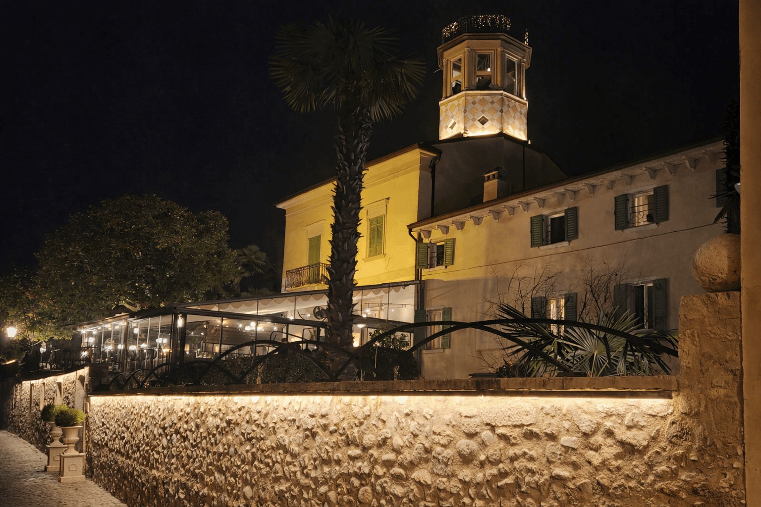 Villa historique illuminée la nuit à Lazise, terrasse de restaurant, lac de Garde