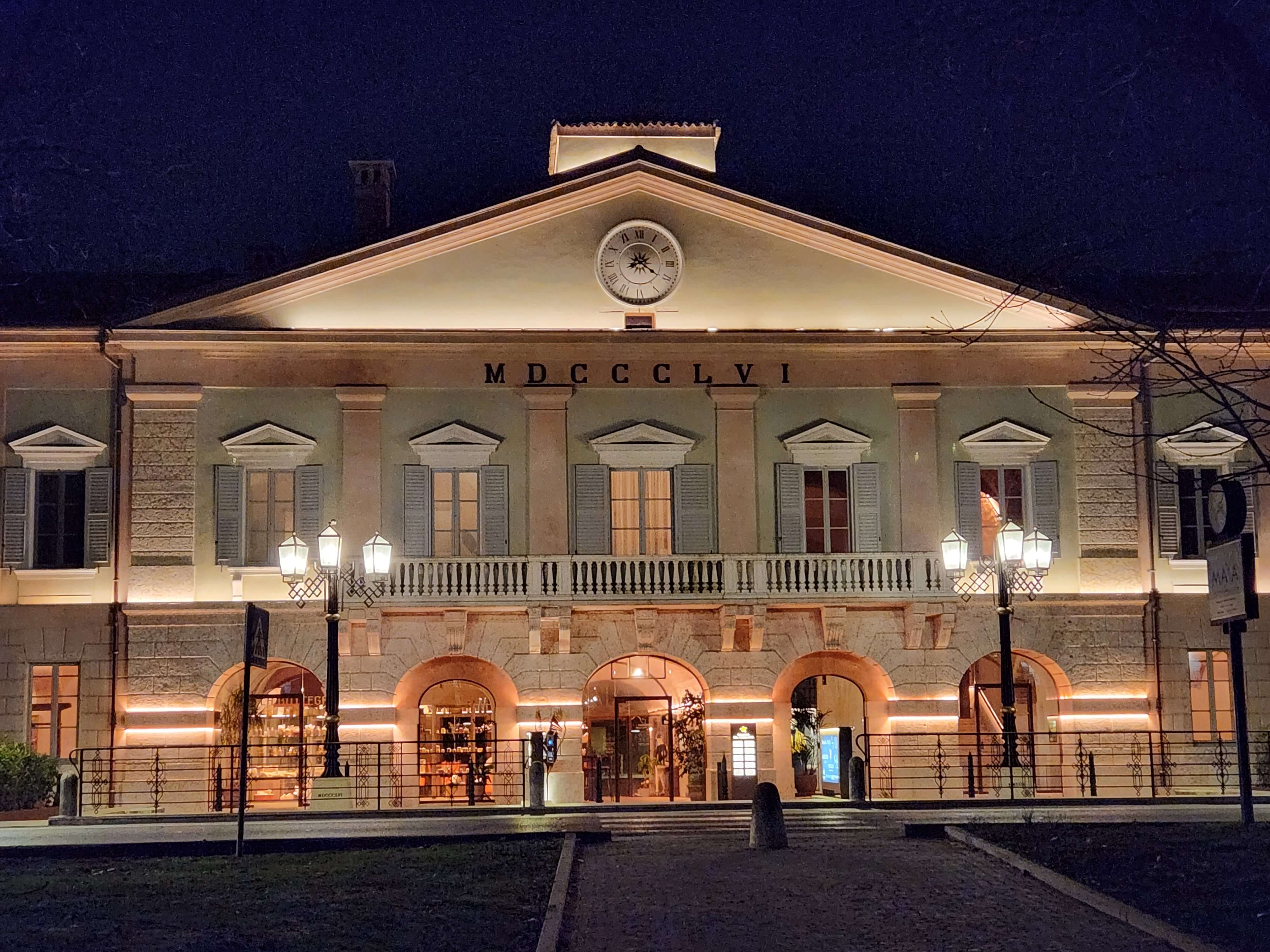 Façade néoclassique MDCCCLVI illuminée la nuit à Peschiera del Garda