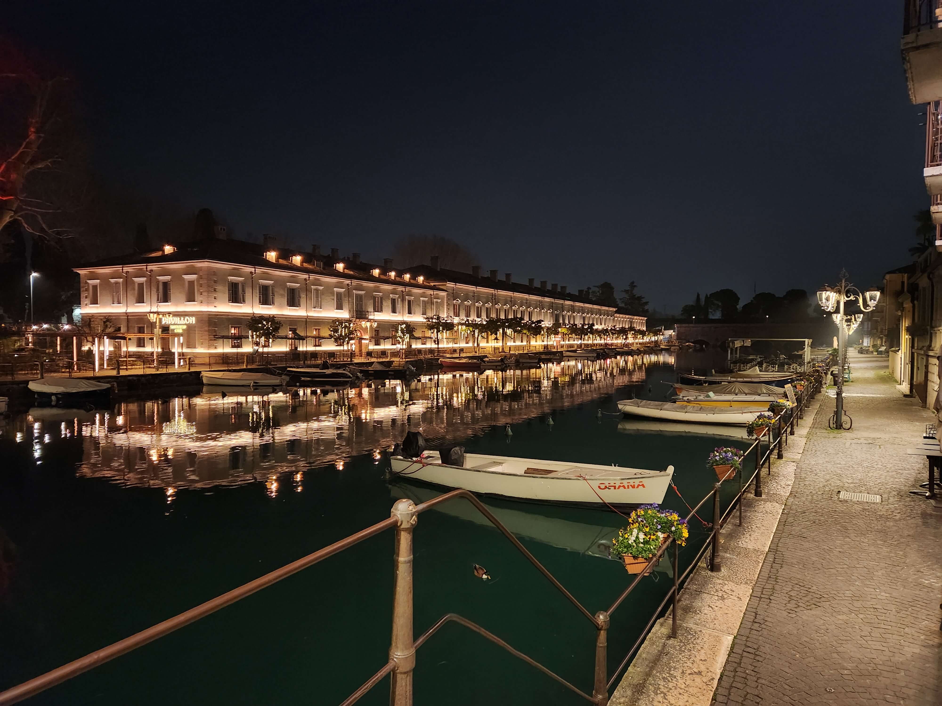 Port intérieur de Peschiera del Garda la nuit, bateaux et reflets dans l'eau