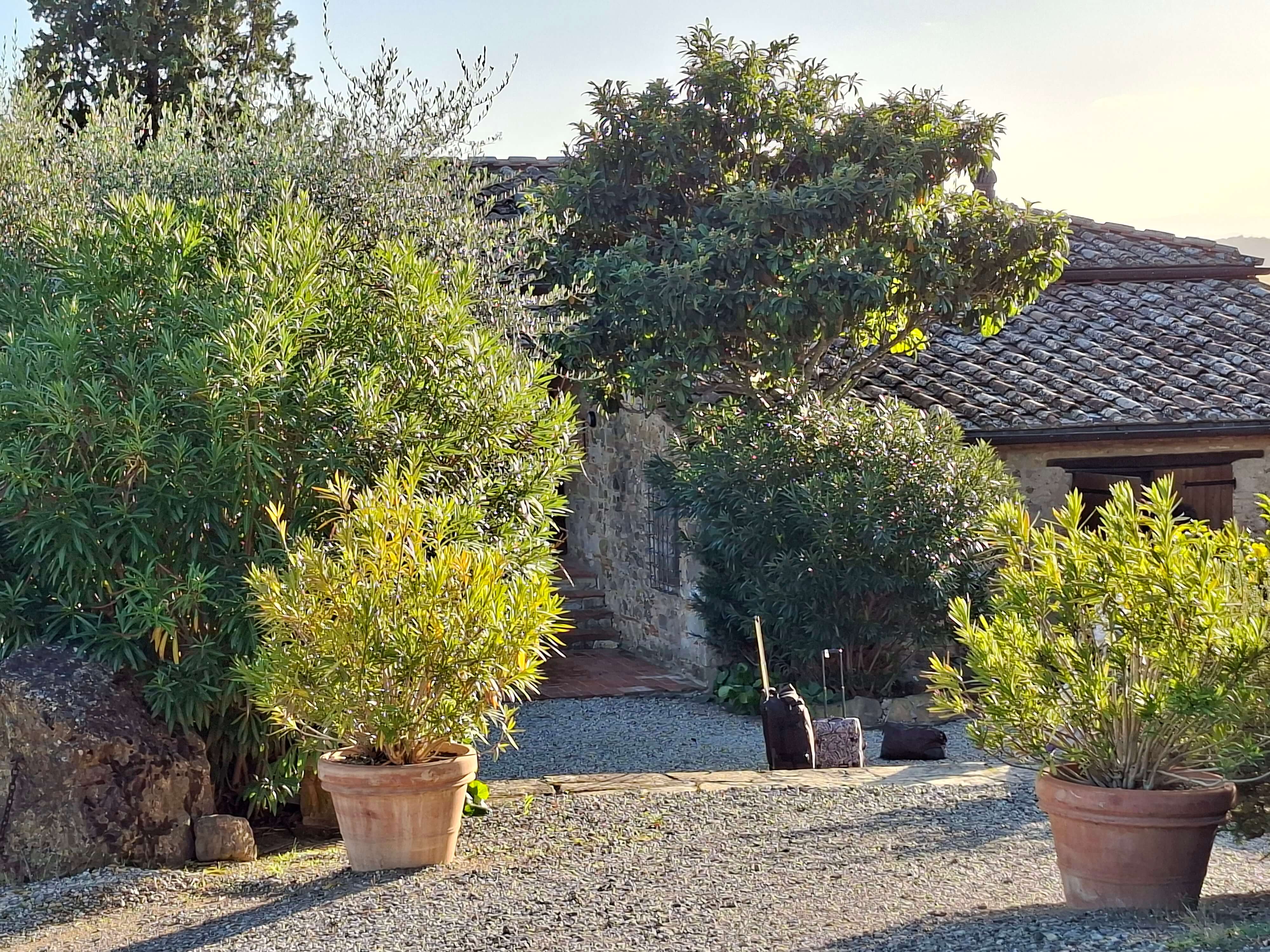 Entrée de l'agriturismo toscane avec ses poteries et son mur de pierre