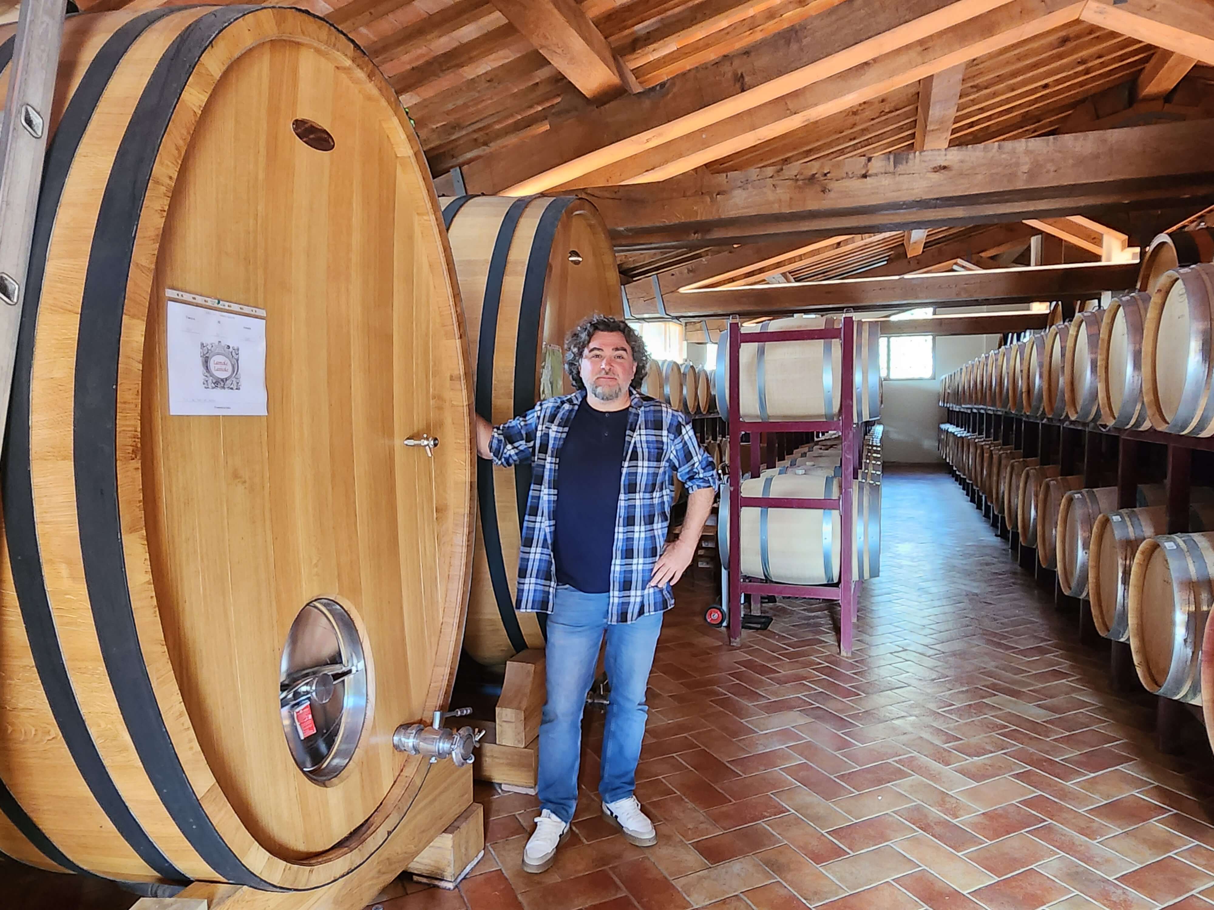 Armel Michenaud devant les foudres ovales et les barriques du domaine